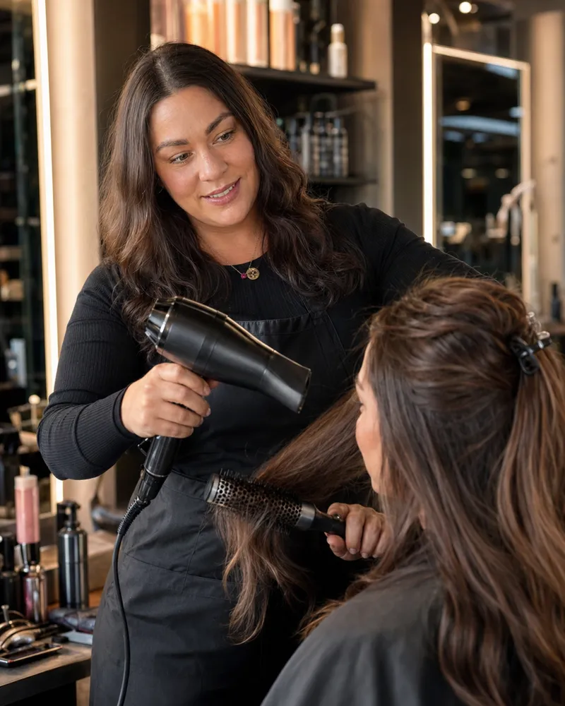 Lucy Chalk styling a client's hair